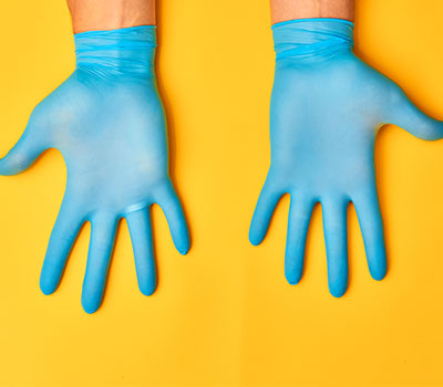 infection control - hands in plastic gloves