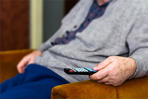 TV licence fee - an elderly man with TV remote in hand