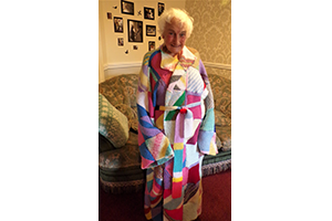 Hazelgrove Court Care Home resident Joyce Baxtrum modelling a dressing gown created by residents as part of a Knit for Peace UK initiative
