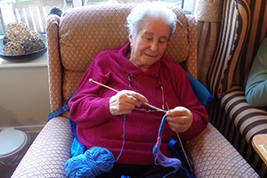 Hazelgrove Court Care Home resident Pat Keleher knitting a belt for a dressing gown as part of a Knit for Peace UK initiative