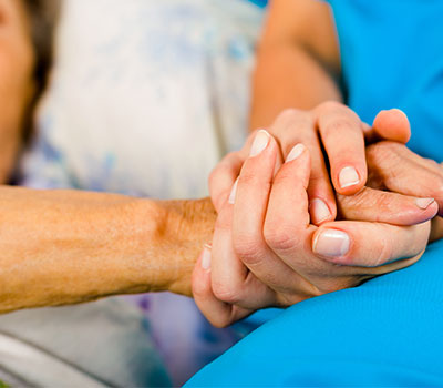 Social care – a nurse holds an elderly patient's hand
