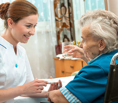 healthcare – a nurse helps an elderly resident with her medication