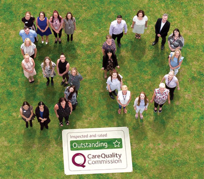 Home Instead Senior Care staff celebrating receiving their 50th “outstanding” CQC rating
