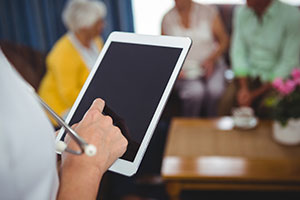 Social care sector urged to back recruitment campaign - nurse on ipad