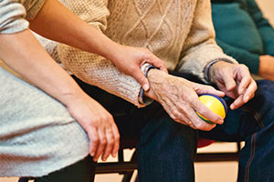 social care - a woman holds an elderly man's hand