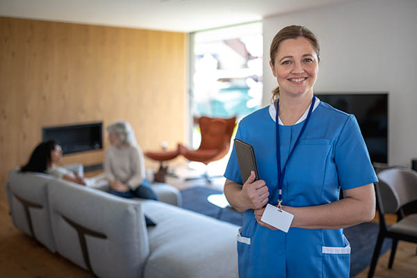 Portrait of nurse with a stethoscope at the patient's home. The Nurse looks at the camera